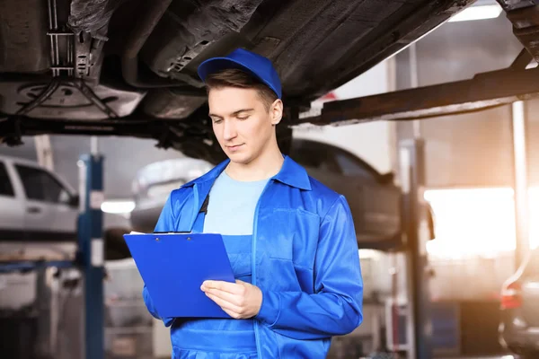 Male Mechanic Clipboard Examining Car Service Center — Stock Photo, Image