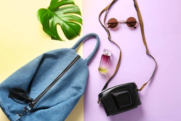 Sırt çantası, fotoğraf makinesi ve kadın aksesuarları renk arka plan üzerinde düz yatıyordu kompozisyonu