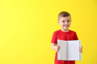 Renklerle ilgili kitabı olan sevimli bir çocuk.
