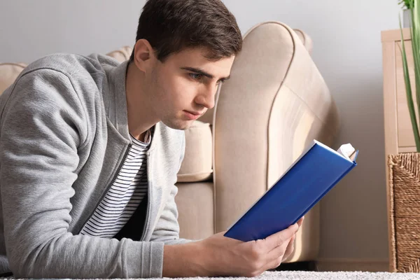 Bonito Jovem Lendo Livro Casa — Fotografia de Stock