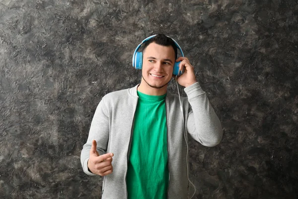 Joven Guapo Escuchando Música Sobre Fondo Gris — Foto de Stock