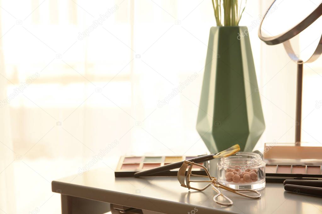 Dressing table with professional makeup cosmetics and eyelash curler