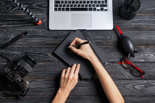 Female Photographer Writing Notebook Table Top View — Stock Photo, Image