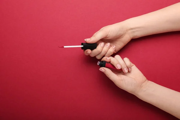 Mãos Femininas Com Manicure Segurando Brilho Labial Fundo Cor — Fotografia de Stock