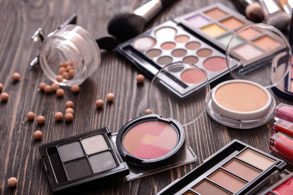 Профессиональная косметика для макияжа на деревянном столике
