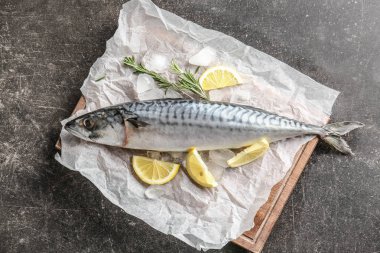 Ahşap tahta ile gri masada lezzetli çiğ uskumru balığı
