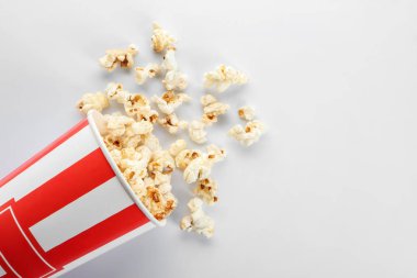 Devrilmiş kağıt bardak beyaz zemin üzerine lezzetli patlamış mısır