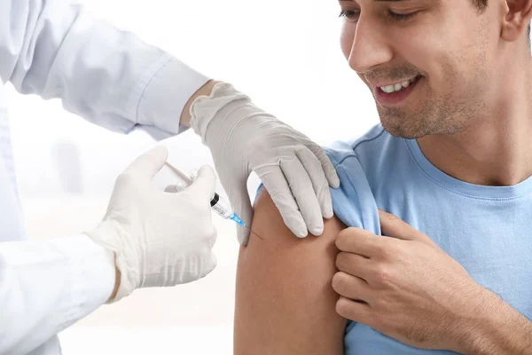 Legen Vaksinerer Mannlig Pasient Klinikk stockbilde