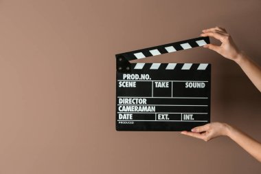 İle sinema Klaket renk arka plan üzerinde eller