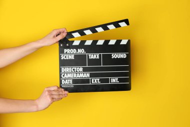 İle sinema Klaket renk arka plan üzerinde eller