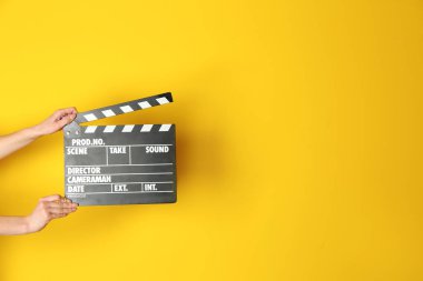 İle sinema Klaket renk arka plan üzerinde eller
