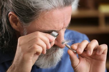 Değerli taş atölyesinde, closeup inceleyerek kuyumcu