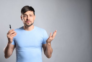 Gri arka plan üzerinde ustura ile karışık adam