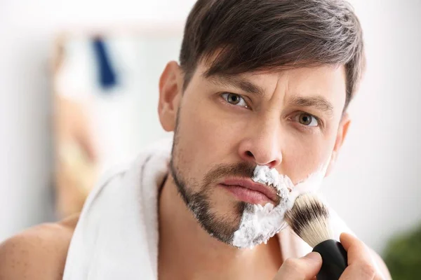 Bonito Homem Aplicando Espuma Barbear Seu Rosto Banheiro — Fotografia de Stock