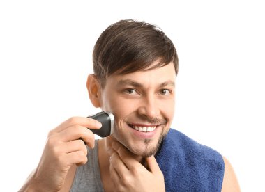 Beyaz arka plan karşı elektrikli tıraş makinesi kullanan yakışıklı adam