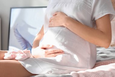 Bebek Patikleri yatak, closeup ile güzel bir hamile kadın