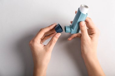 İnhaler astım ışık arka plan üzerinde karşı ile eller