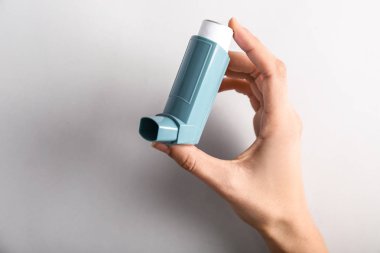 El ile inhaler astım ışık arka plan üzerinde karşı