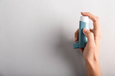 El ile inhaler astım ışık arka plan üzerinde karşı