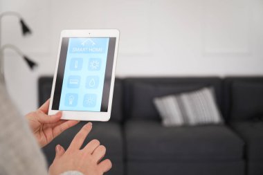 Genç kadın akıllı ev otomasyonu uygulamasını kullanıyor