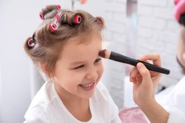 Genç anne kozmetik yüzü sevimli kızı evde üzerine uygulama