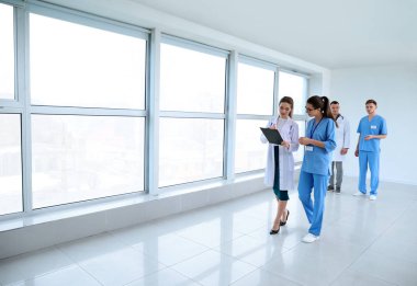 Klinik koridorda yürürken hekimlerin