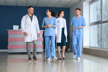 Klinik koridorda yürürken hekimlerin