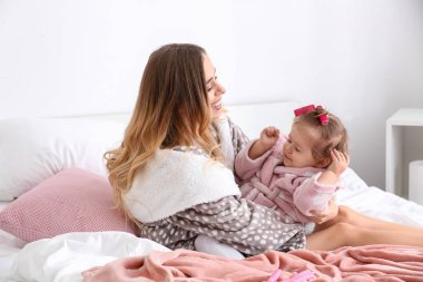 Sevimli küçük kızını evde saç yapıyor olan kadın