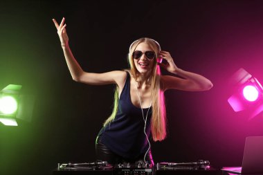 Kulüpte müzik çalan kadın DJ.