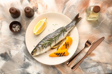 Plaka ile lezzetli levrek balık renk arka plan üzerinde pişmiş.