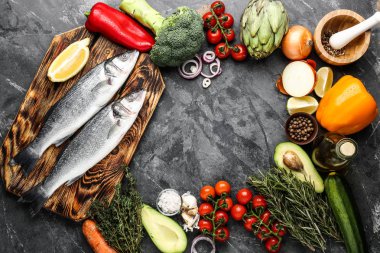 Gri arka plan üzerinde ürünleri, çiğ levrek balık çerçeve yaptı