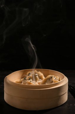 Bambu vapur koyu arka plan üzerinde lezzetli sıcak köfte ile