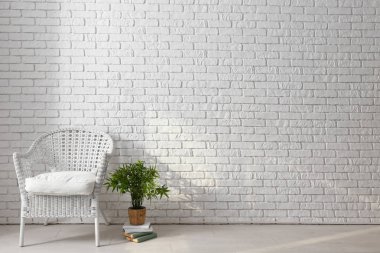 Beyaz tuğla duvarının yakınında konforlu koltuk