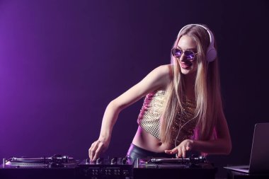 Kulüpte müzik çalan kadın DJ.