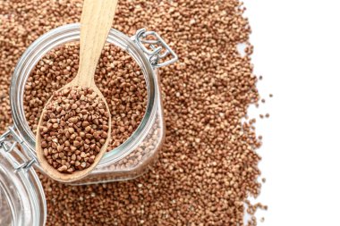 Cam Kavanoz ve beyaz arka plan, üstten görünüm üzerinde ham buğday kaşıkla