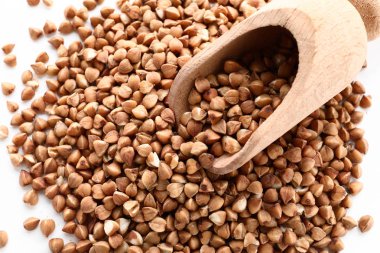 Ahşap kepçe ve beyaz arka planda, closeup ham buğday