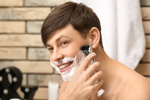 英俊的男人在浴室中刮胡子 — 图库照片