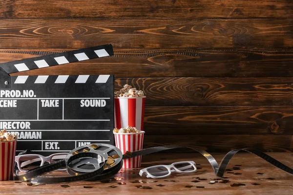 Película Clapper Con Carrete Película Palomitas Maíz Vasos Mesa Madera — Foto de Stock