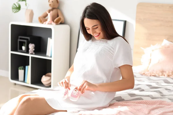 Mooie Zwangere Vrouw Met Baby Slofjes Slaapkamer — Stockfoto