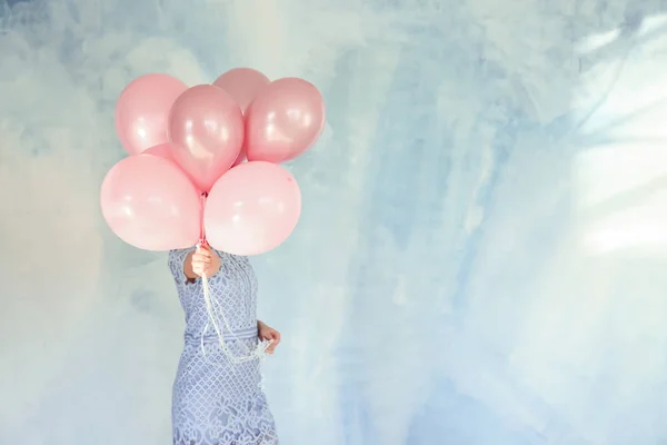 色の背景上の誕生日風船を持つ若い女性 — ストック写真