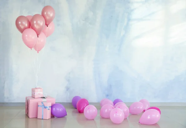 Birthday balloons with gift boxes in room