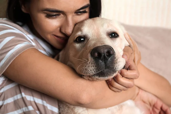 家庭で彼女のかわいいラブラドール犬を持つ若い女性の肖像画 — ストック写真
