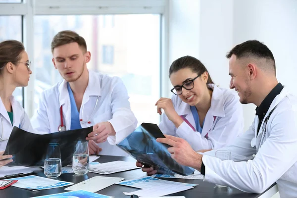 Team of doctors discussing diagnosis at table in clinic