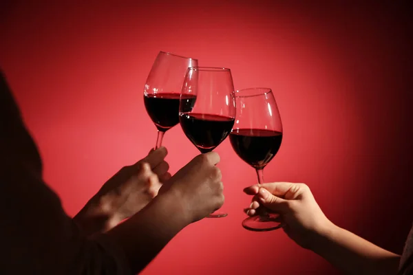 Femmes Cliquetis Verres Avec Vin Rouge Savoureux Sur Fond Couleur — Photo