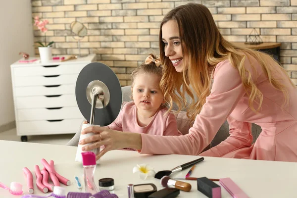 化粧品を自宅で遊ぶかわいい小さな娘を持つ若い女性 — ストック写真