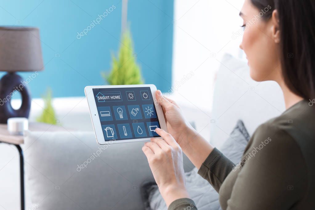 Young woman using application of smart home automation