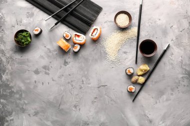 Gri arka plan üzerinde farklı lezzetli suşi rulo
