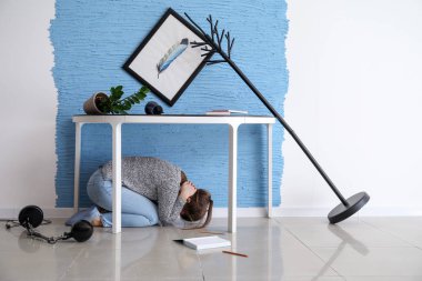 Genç kadın deprem sırasında masanın altında gizleme