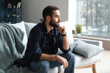 Evde koltukta oturan yakışıklı şık adam