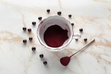 Bardak ve kaşık ile acai toz ışık arka plan üzerinde